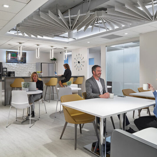 photo of people in a cafe where 2 people are holding mugs and smiling