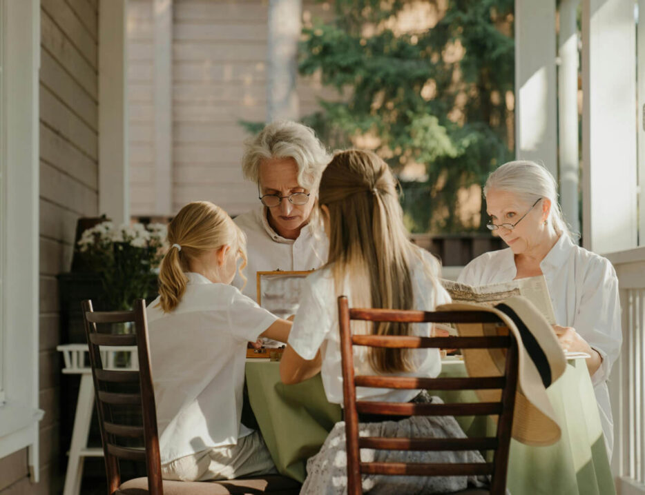 grandparents and grandchildren sit on the porch
