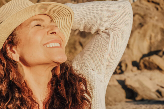 smiling single woman wearing a hat outdoors
