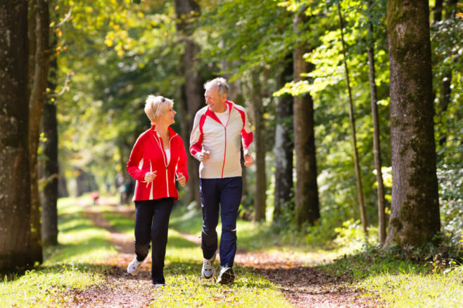 retired couple jogging in the woods