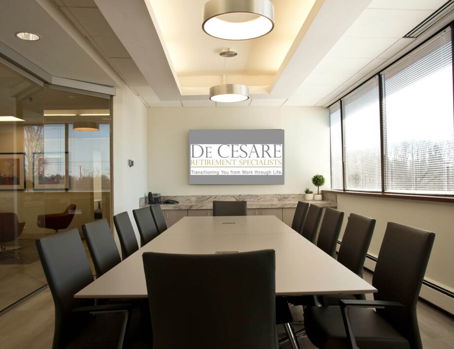 photo of empty board room with a screen that shows De Cesare logo