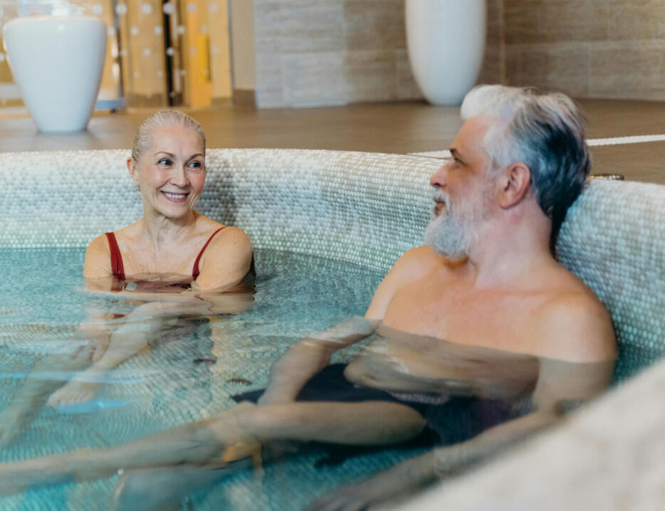 A retired couple relaxes in a resort hot tub